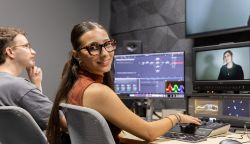 Yound woman sitting at computer looking at camera