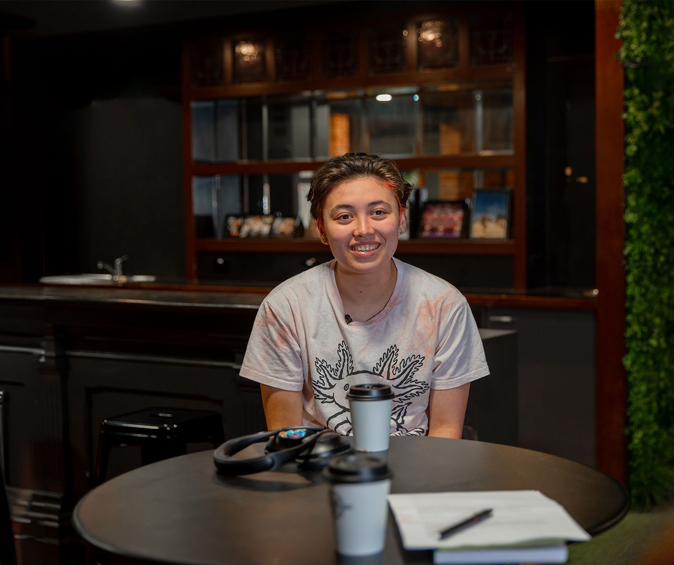 Student of Swinburne University, sits at a café on a table across from the interviewee. 