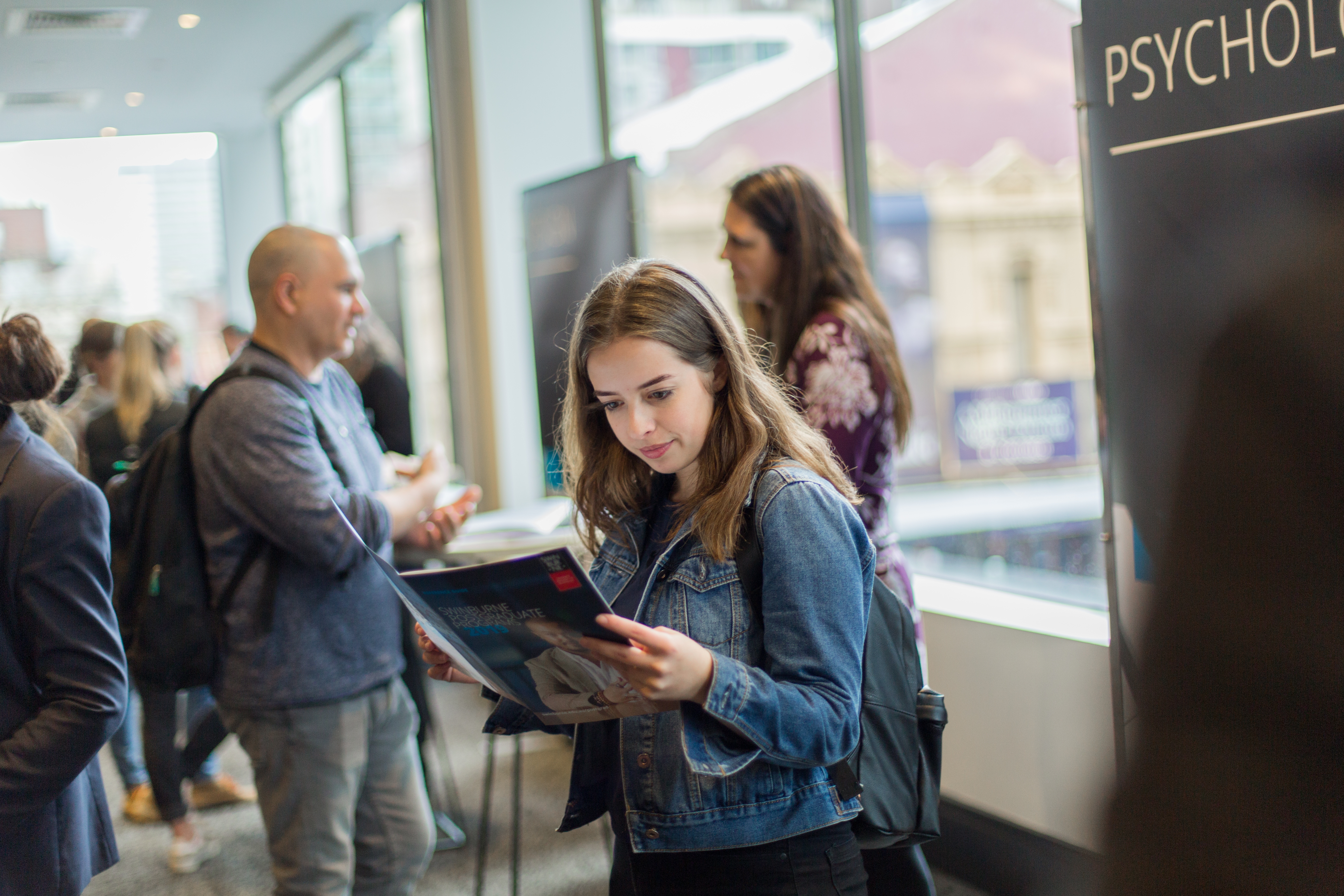 Young female student reads through the course guide 