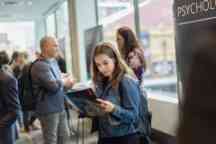 Young female student reads through the course guide 