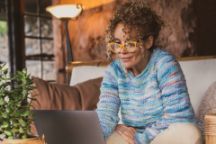 Smiling Woman Using Laptop At Home.
