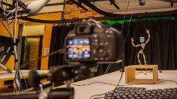 An animation studio with camera pointed at a small person-like character.