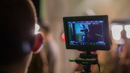 A film crew member filming a camera with a camera