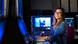 female student at the sound and audio studio looking and smiling at the camera