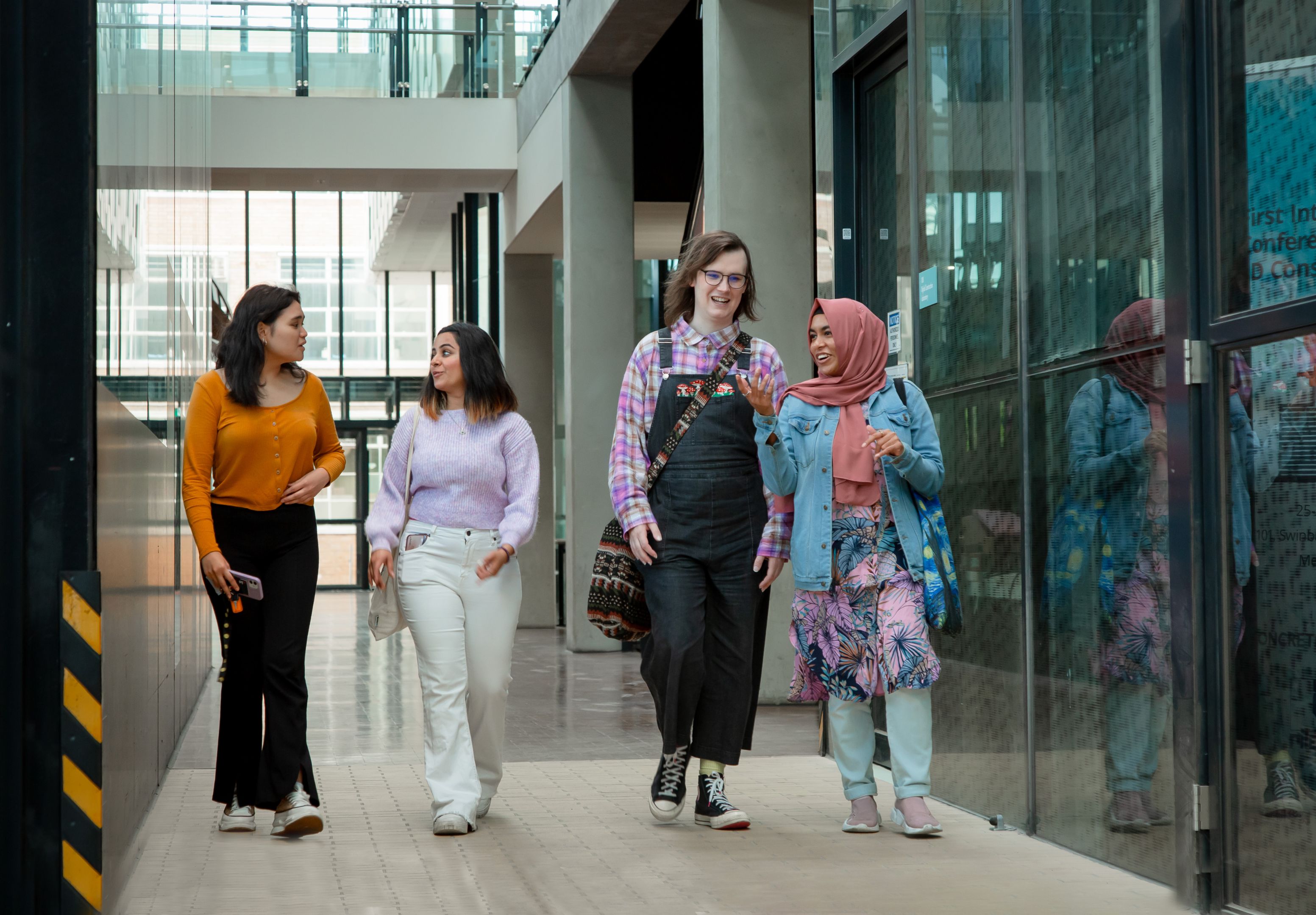 Four students walking down a corridor in Swinburne’s Advanced Technologies Centre. 