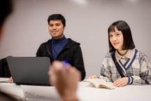Two international students having a discussion in a classroom