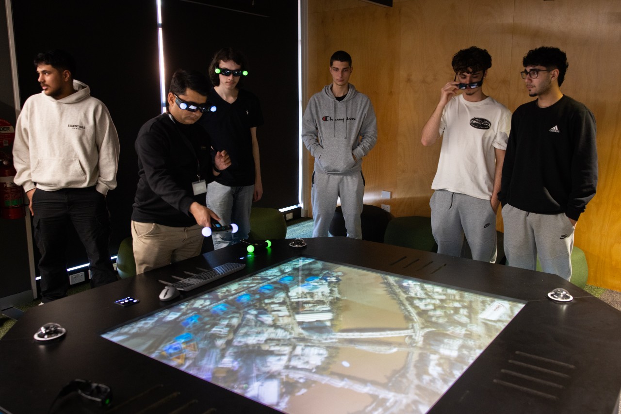 Students collaborating using the Axiom Holographic Table to review and explore 3D designs for construction planning and asset management.