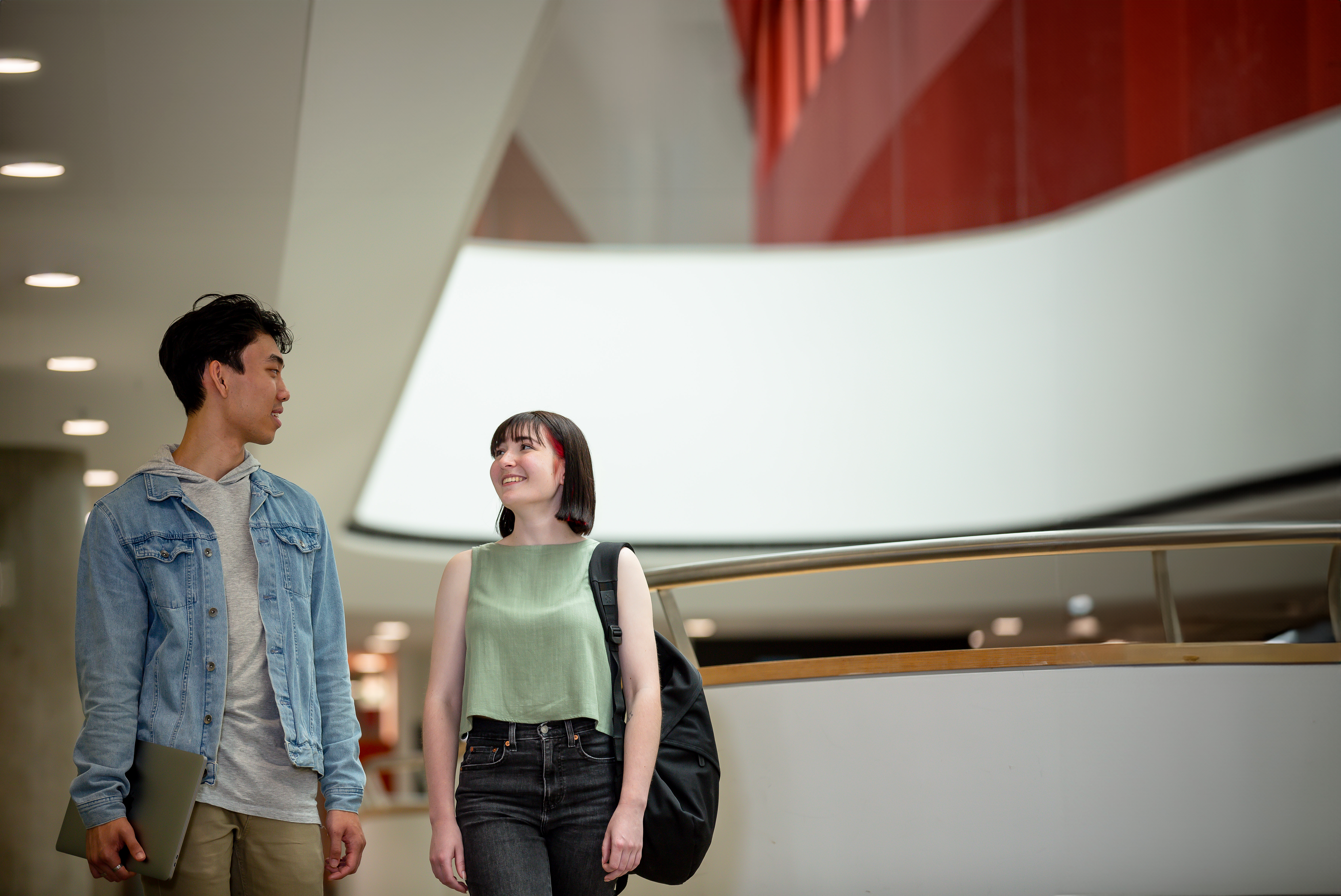 Two students chat as they walk through Swinburne’s AMDC Building.