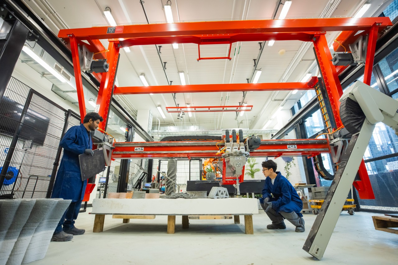 Students being shown a large-scale 3D concrete printer in the Digital Construction Lab