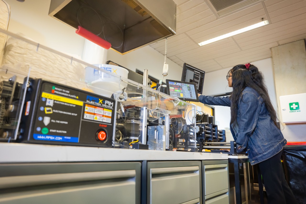 Student using the APSX-PIM Plastic Injection Moulding Machine to create a test specimen in Swinburne's Polymer Processing and Testing Lab