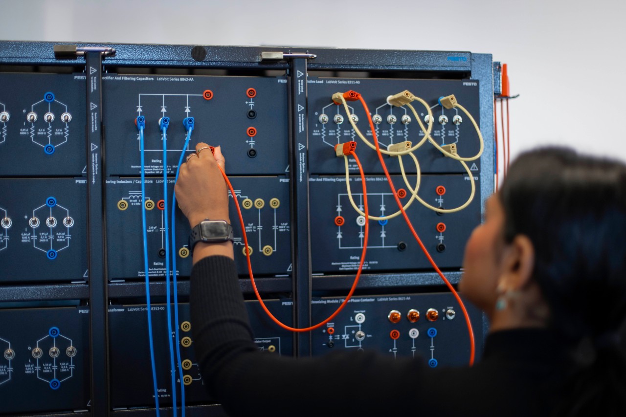 A student plugging wires into Festo LabVolt hardware