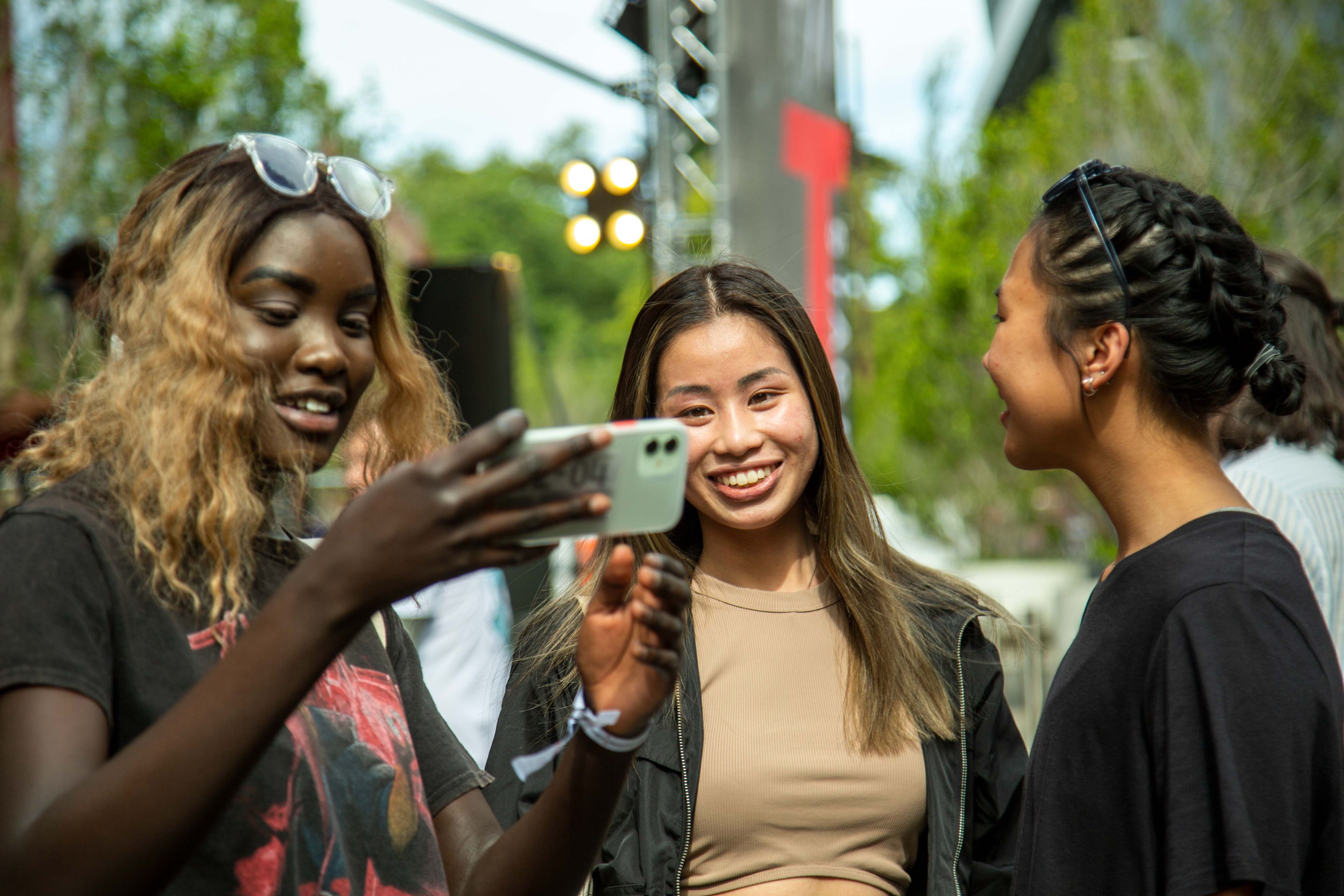 Three girls smiling looking at a phone