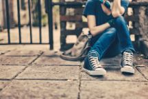 A young girl sitting outside on a street