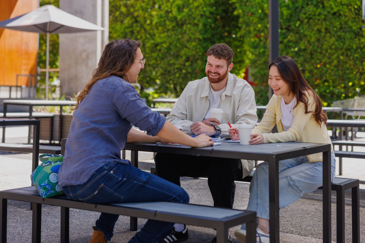 Three students at Swinburne Hawthorn campus sitting at a table