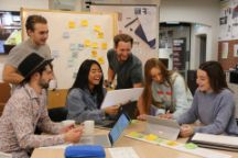 A group of six people/students discussing.