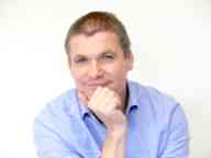 Cobalt Design's Steve Martinuzzo sitting with his hand resting on his chin, wearing a blue collared shirt.