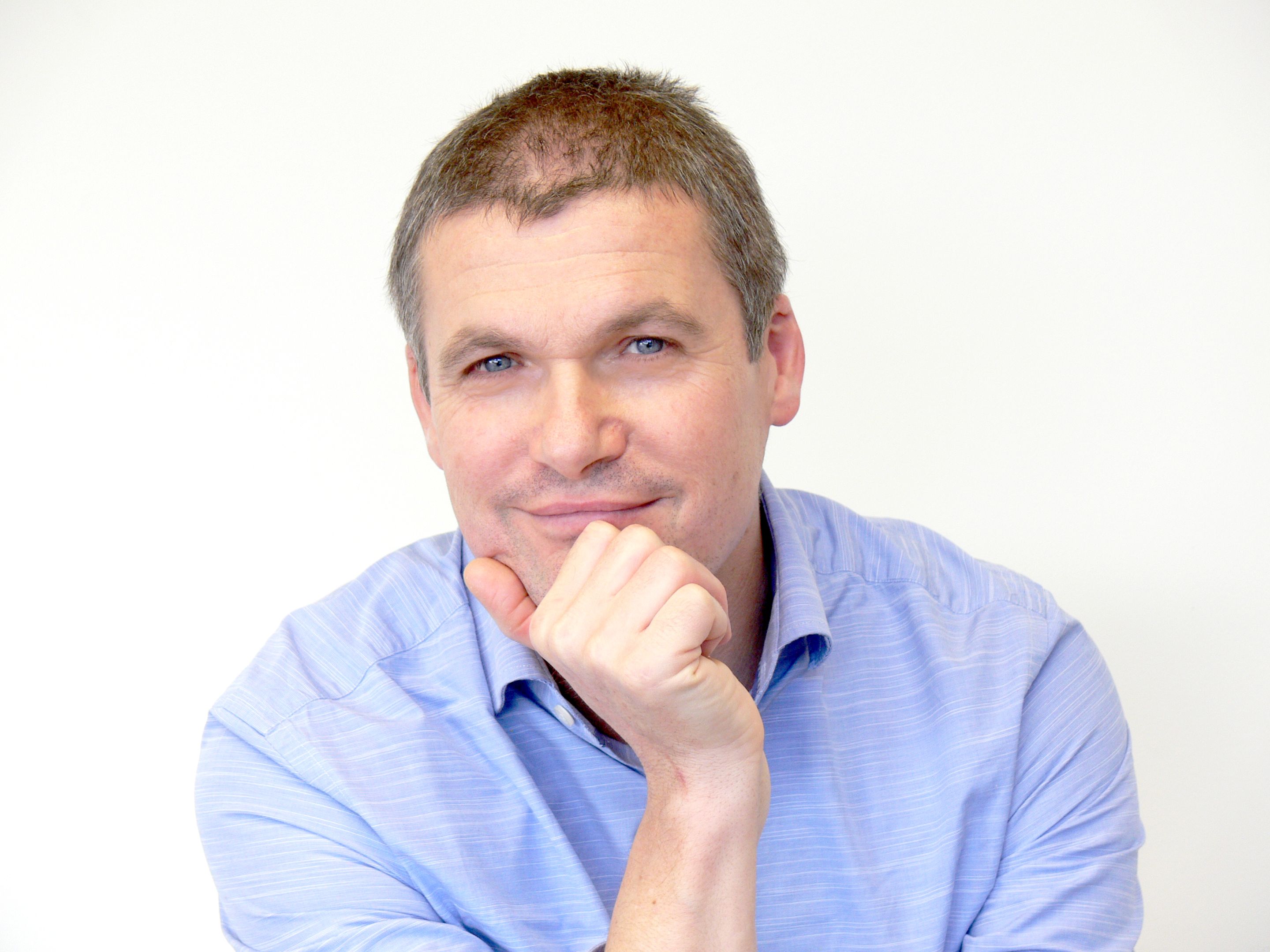 Cobalt Design's Steve Martinuzzo sitting with his hand resting on his chin, wearing a blue collared shirt.