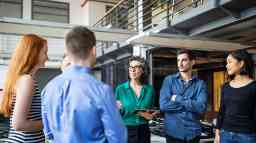 Group of people standing engaged in conversation.