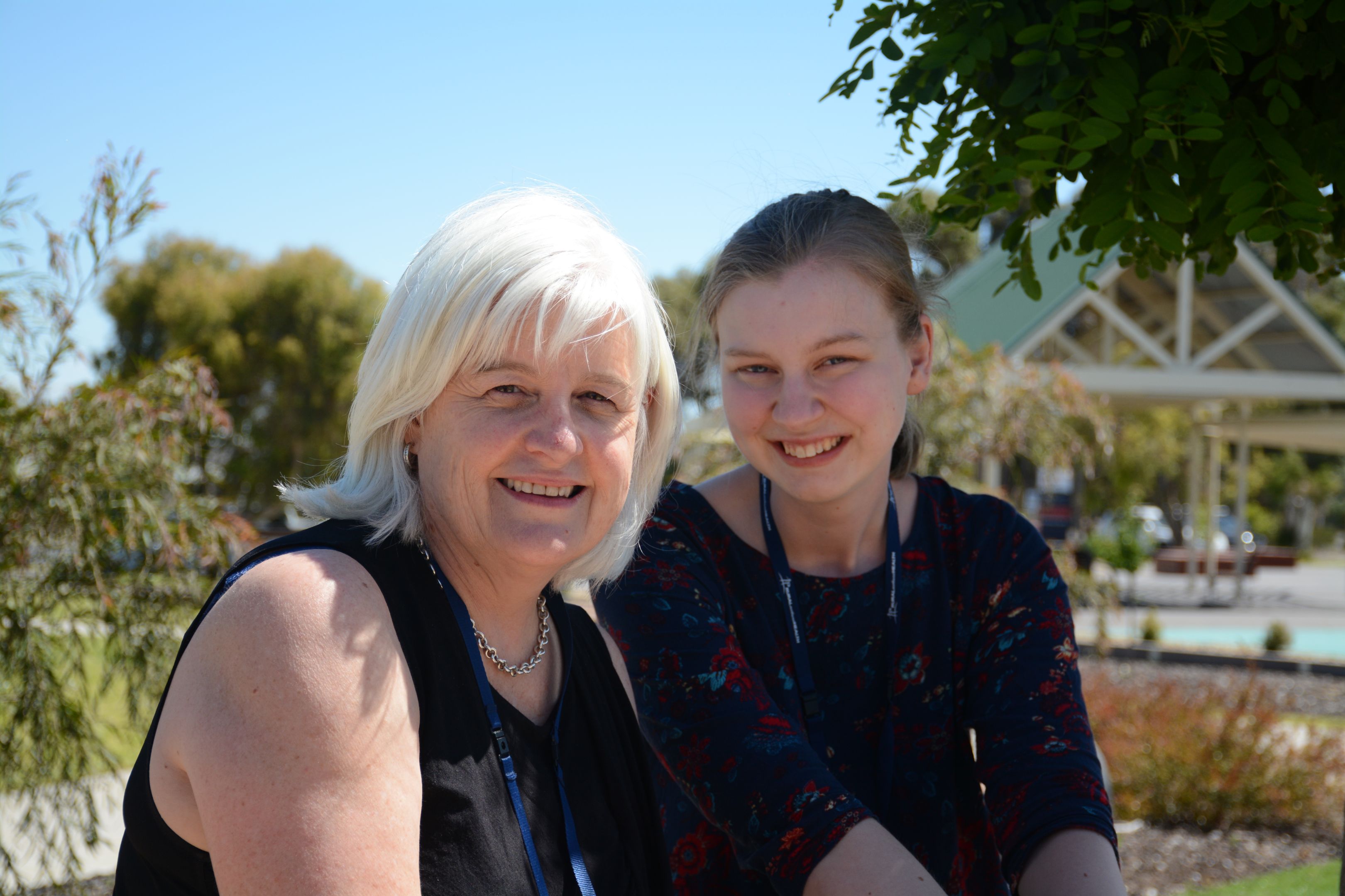 Photograph of Dr Kaye Knight of Rural Northwest Health with a professional placement student. Both women are wearing black and sitting outdoors with trees behind them.