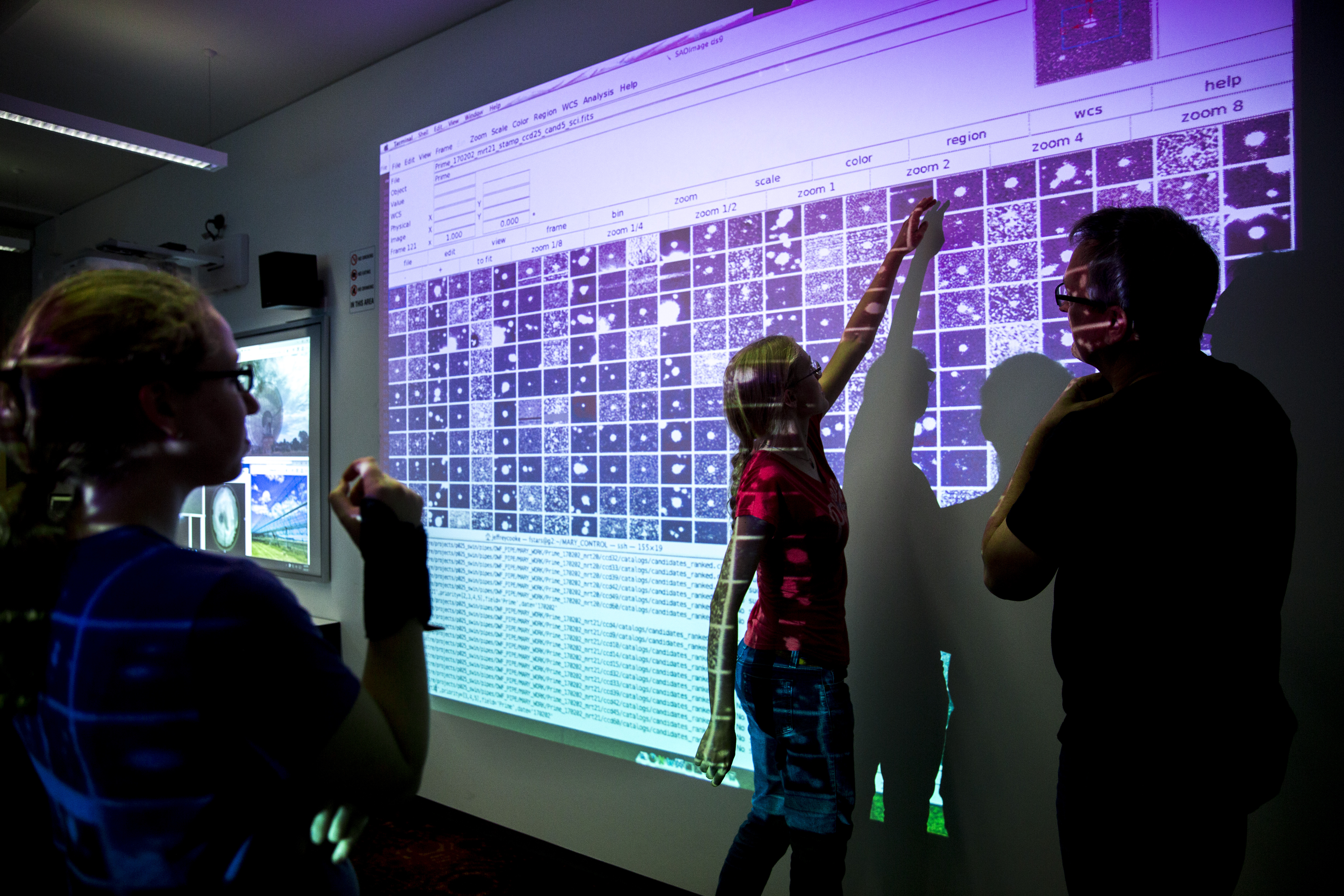 Person pointing up high to a digital screen in a workshop