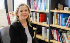 Headshot of professional in an office in front of a bookshelf