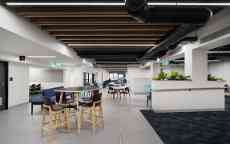 Modern study space with white walls and timber beams.