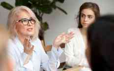 Aged businesswoman, teacher or business coach speaking to young people