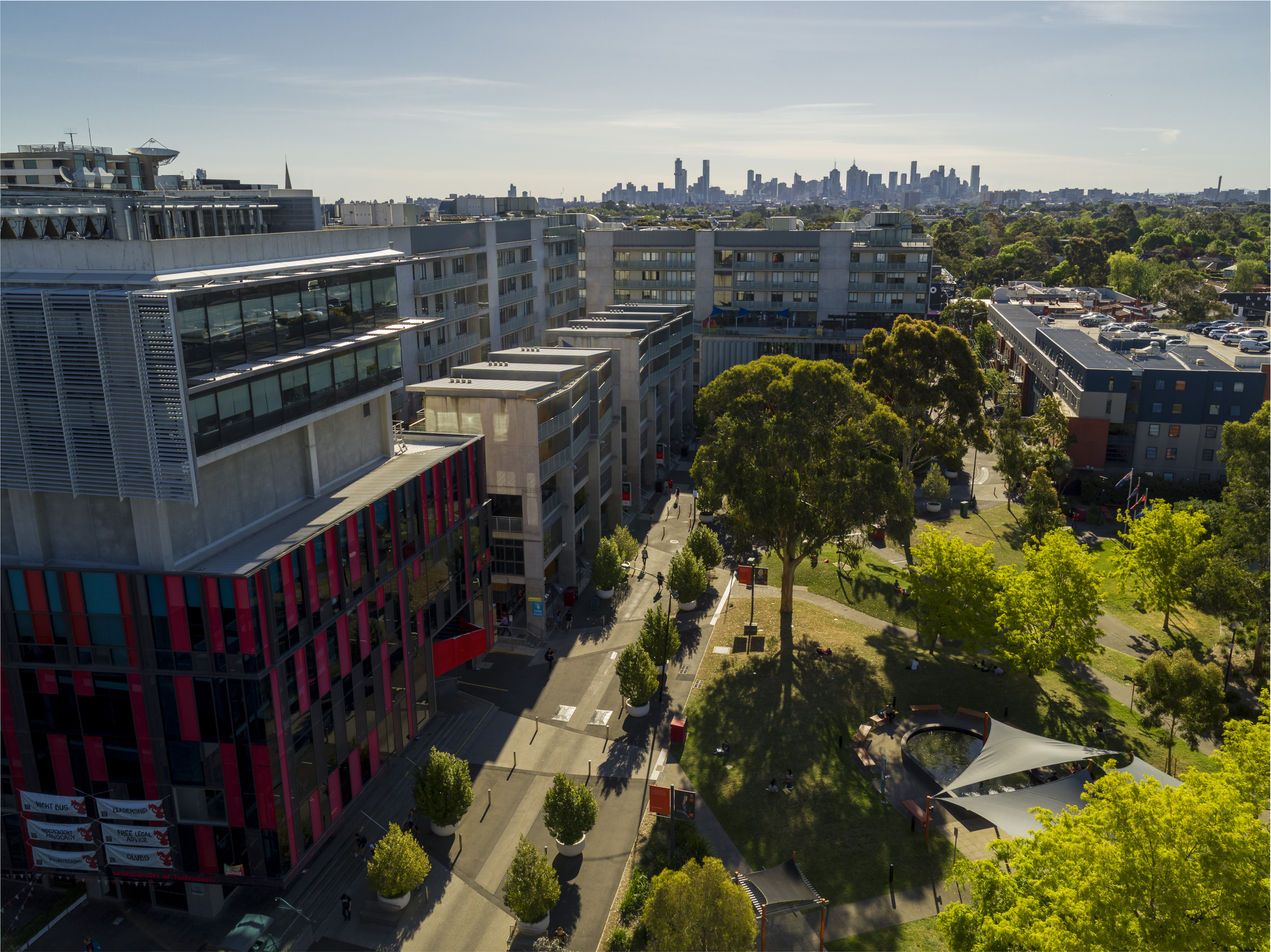 modern buildings rising above a park with green trees