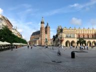 A panoramic view of a cobblestone street in Poland, surrounded by old buildings