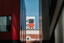 Taken amongst surrounding buildings, the image focuses on the Swinburne logo which is located on a building across campus 