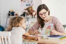 A professional child education therapist having a meeting with a child in a family support center.