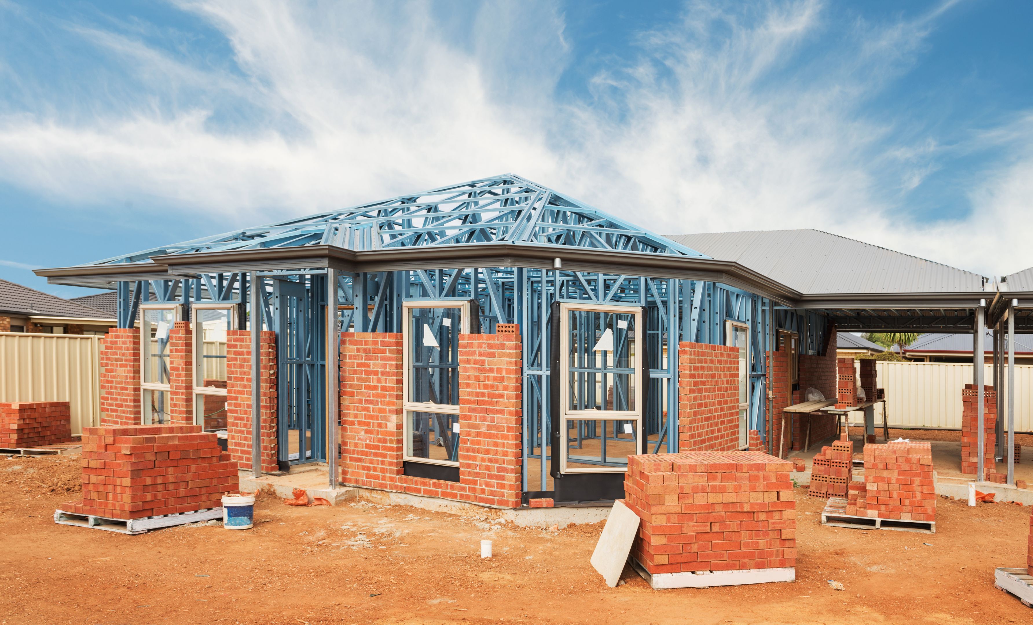 New residential construction home from brick with metal framing against a blue sky