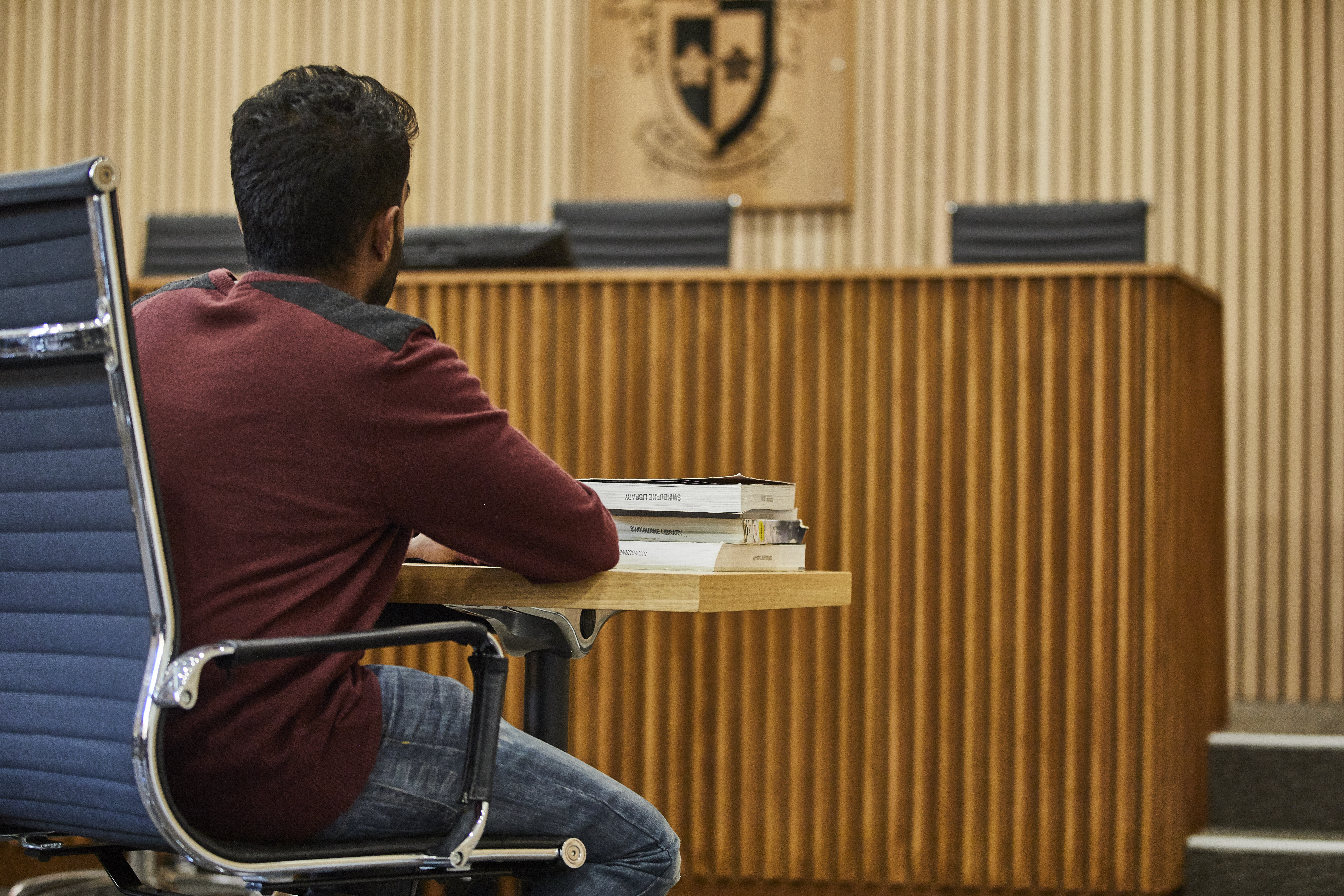student seated facing bench in mock up courtroom