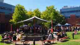 Large crowd eating lunch around pond in Wakefield Gardens on a bright sunny day