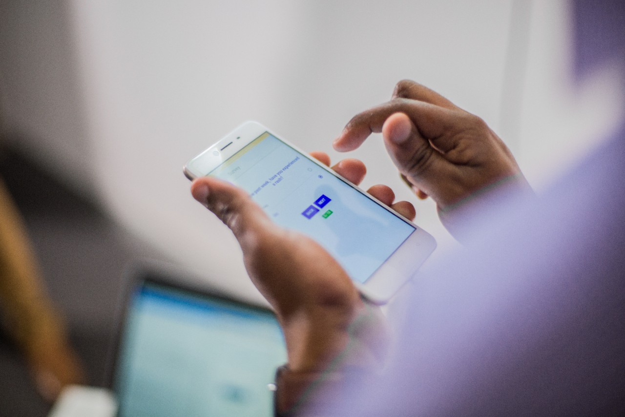 Male student uses his smartphone to connect to a device