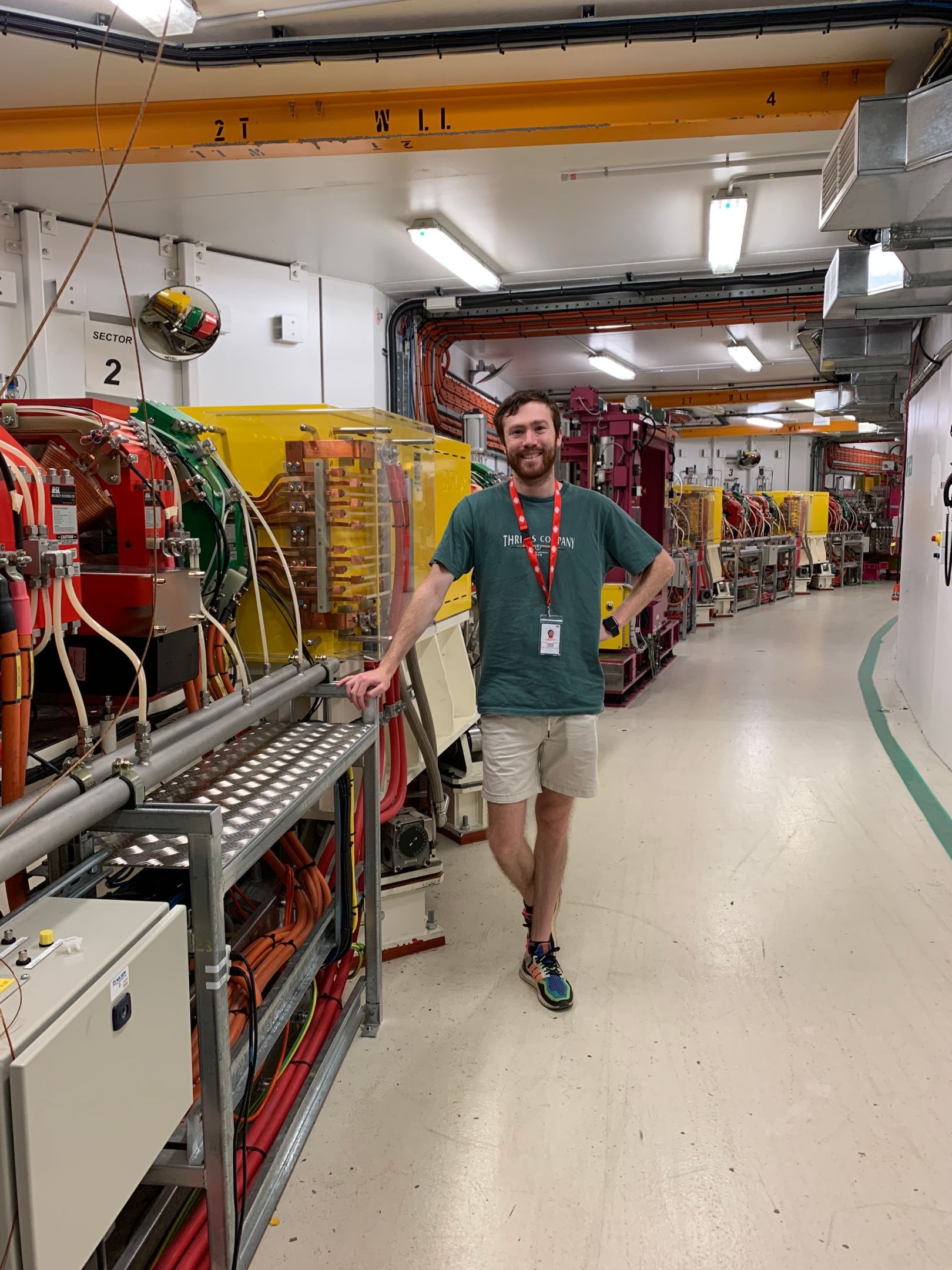 Post-Doctoral Research Fellow at Swinburne's Space Technology and Industry Institute, Matt Large, stands in front of complex machinery at ANSTO's Australian Synchrotron in Melbourne.