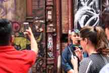Two people taking a scan of a funky bar code on their phone in a Melbourne lane way