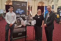 Swinburne researchers Daniel Ricardo, Michelle Dunn, and Philipp Zanon stand with the model of Roo-ver, Australia's lunar rover, at Victorian Parliament House.
