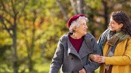 Elderly lady and young woman walking together in a park