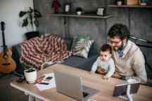 Young single father working from home office and taking care of his baby boy.