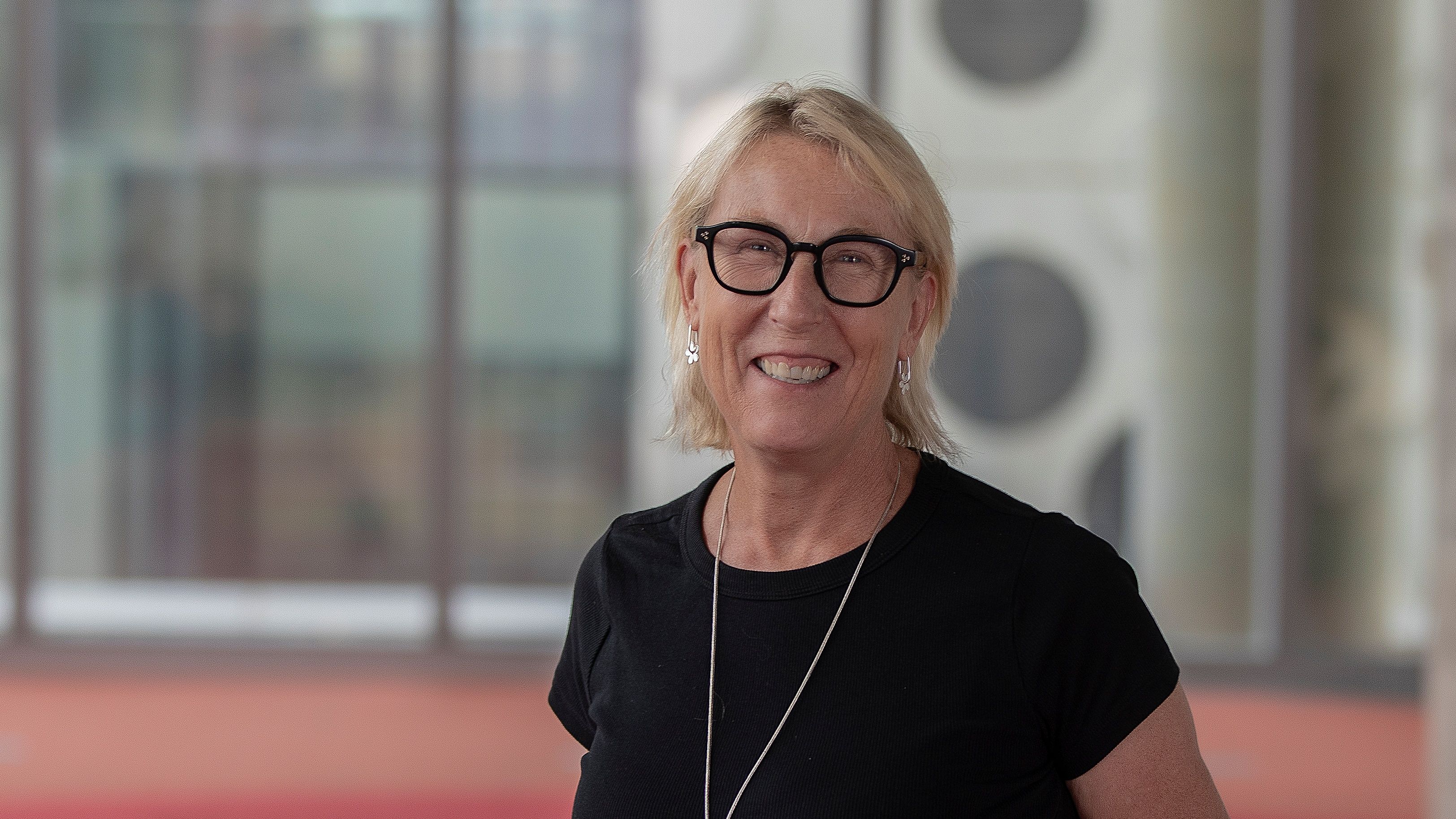 Smiling woman with glasses in black top
