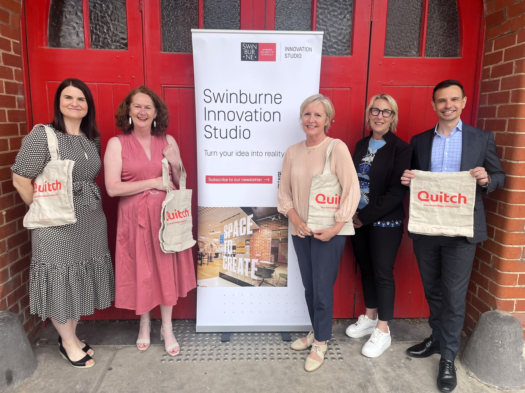 Professionals, academics and researchers standing in front of banner