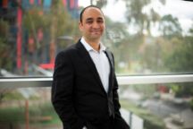 A man stands in a window smiling at the camera