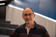 Portrait of a person wearing glasses, smiling slightly.