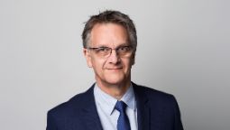 Man with glasses and tie smiling for photo