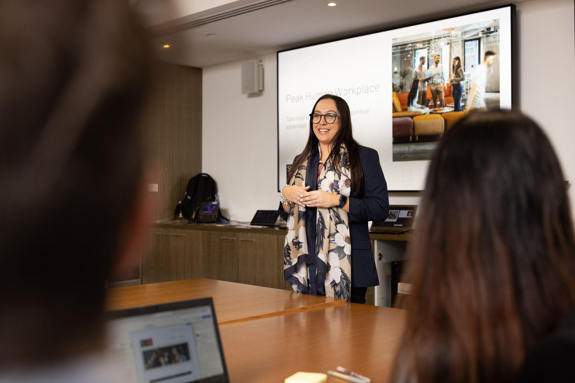 lady presenting 'peak human workplace' to colleuges
