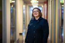 headshot of a women in a blue coat and grey hat
