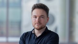 Man with short brown spiky hair in navy polo top