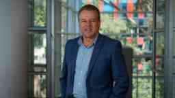 Mid shot of man standing indoors smiling at camera