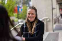Female student ambassador wearing black sits and smiles to camera at Hawthorn campus
